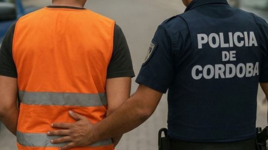 Persona escaneando un código QR en el chaleco de un cuidador de coches en una calle de Córdoba