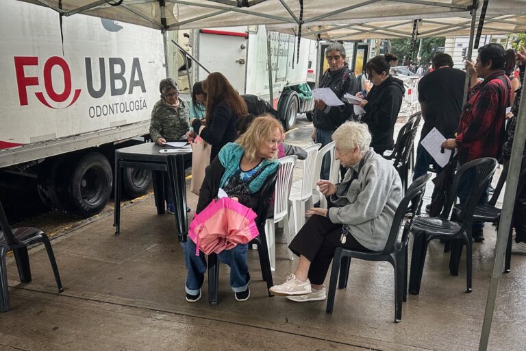Estudiantes y docentes de odontología atienden a un paciente en un consultorio improvisado en la calle.