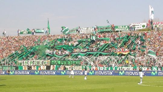Estadio de fútbol con tribunas, ilustrando el regreso del público visitante.
